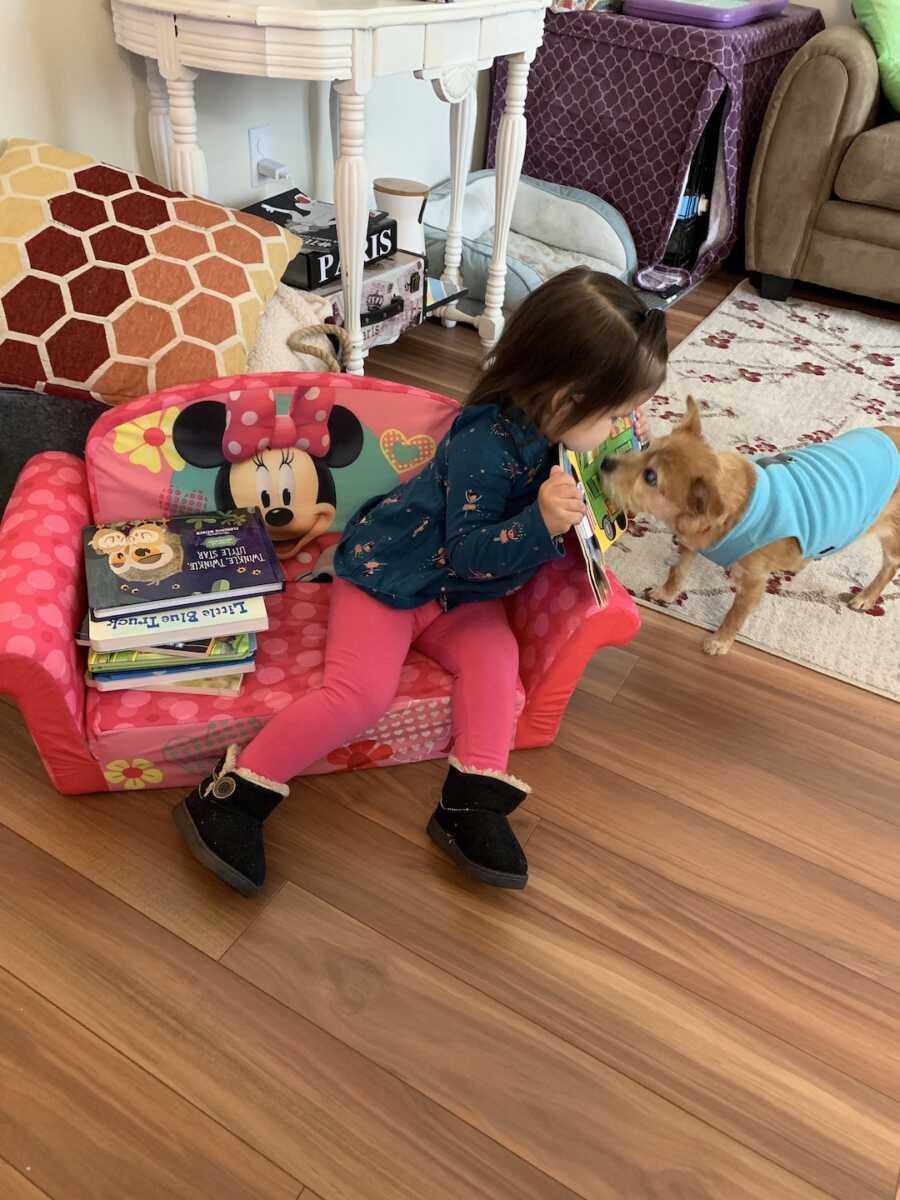 foster child leans over to see dog