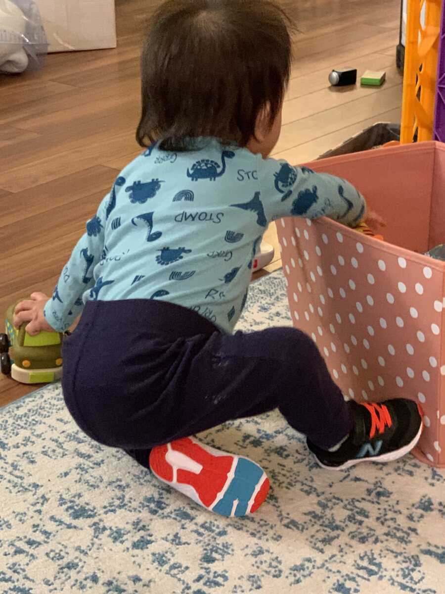 foster child plays in a bin of toys