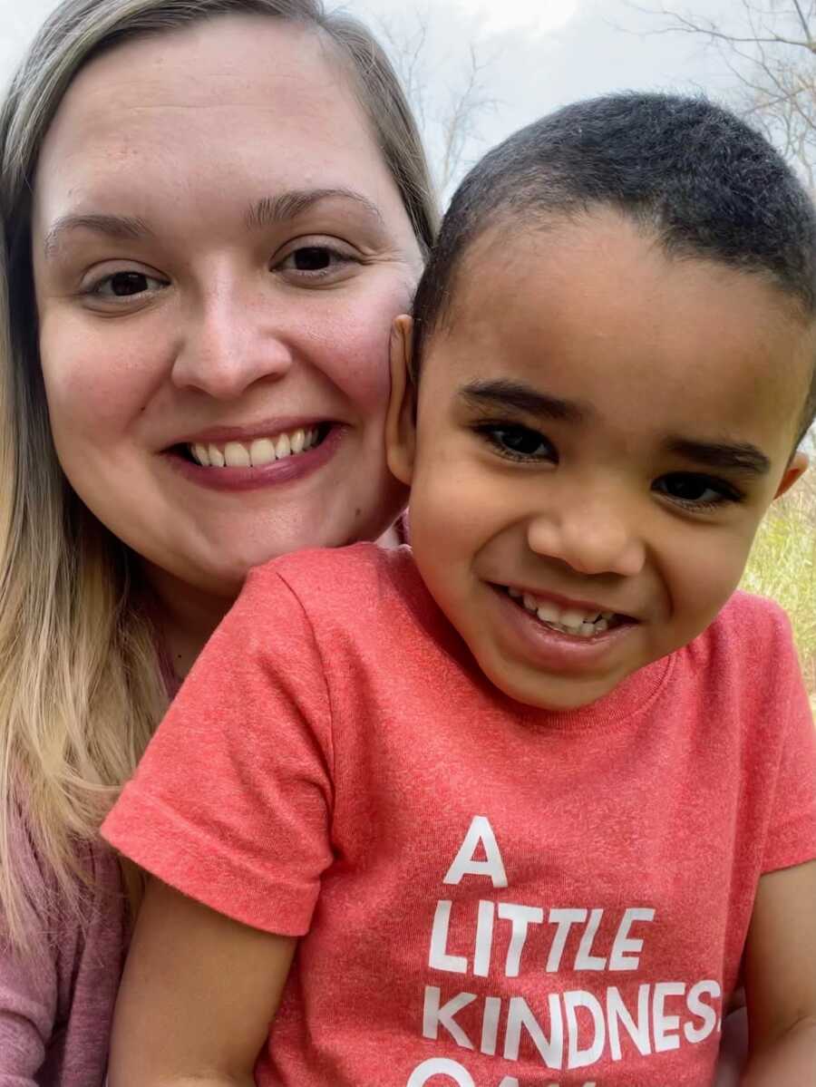 foster mother holding her son smiling