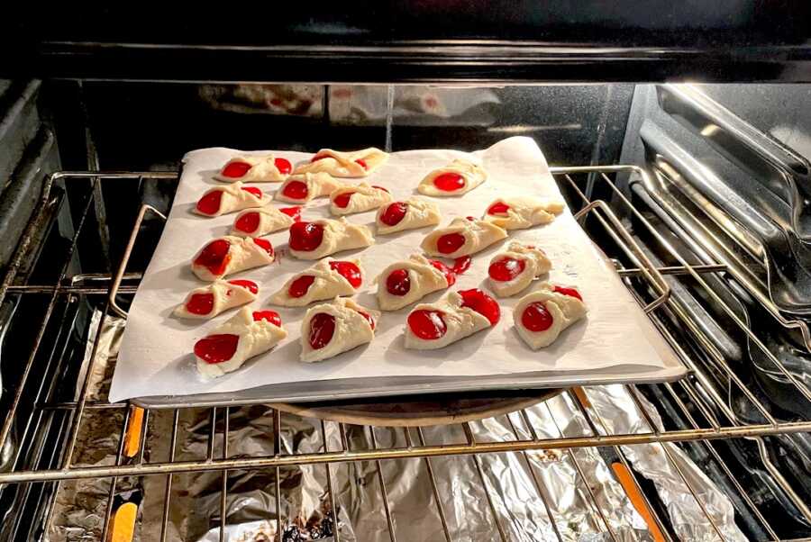 kolaches on baking sheet cooking in the oven