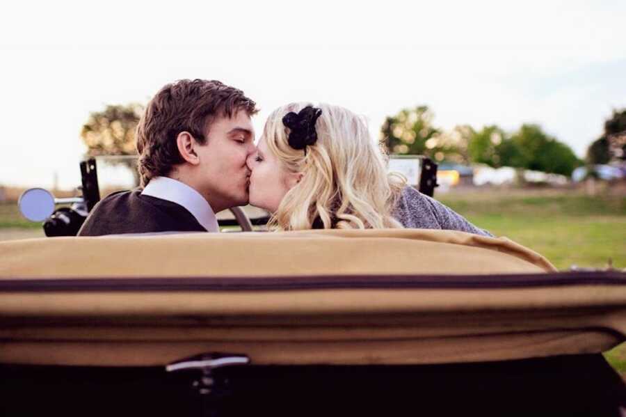 man and woman kiss outside in car