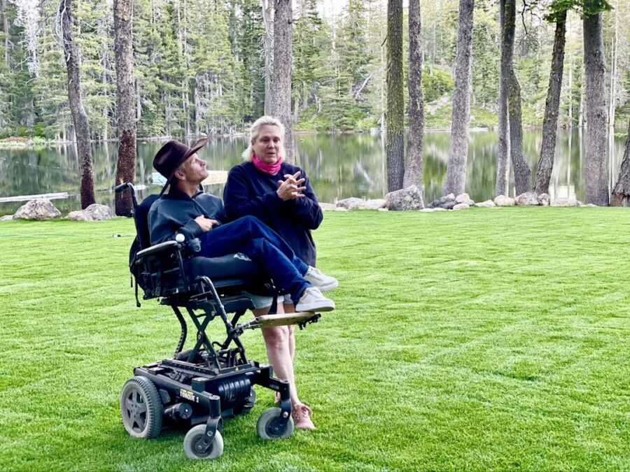 Man with cerebral palsy stands with his wife in a field