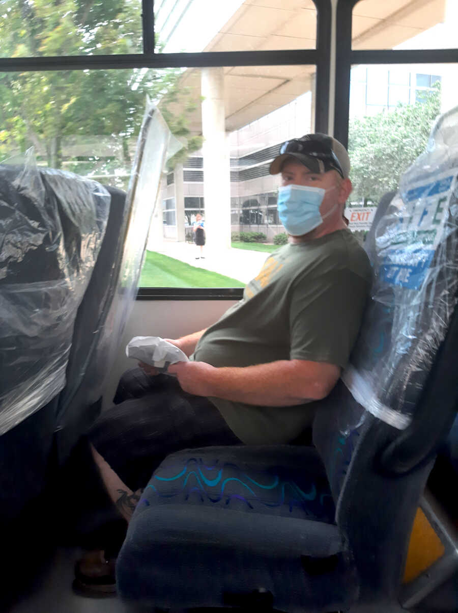 man with melanoma wearing a mask while sitting on the bus