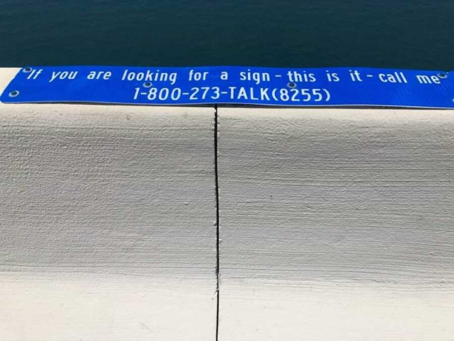 blue mental health sign placed on bridge 