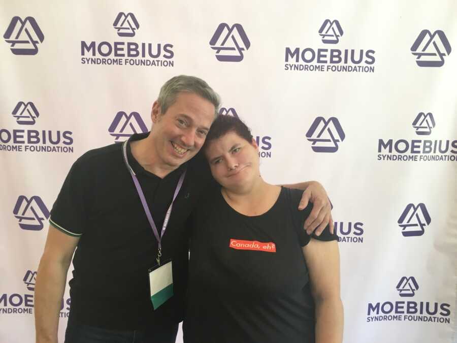 Woman with Moebius Syndrome poses with man at conference 