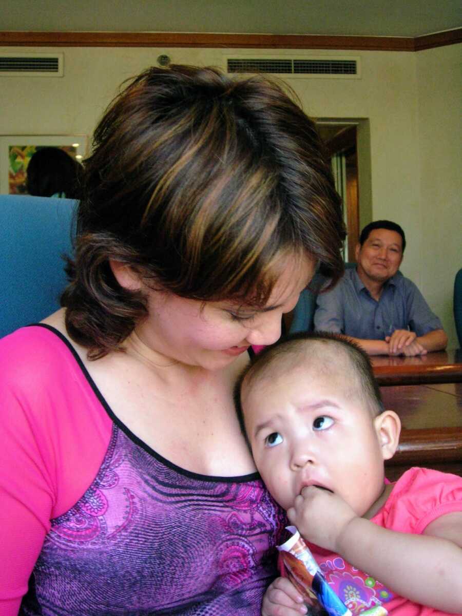 mother sitting with her adopted baby in her lap