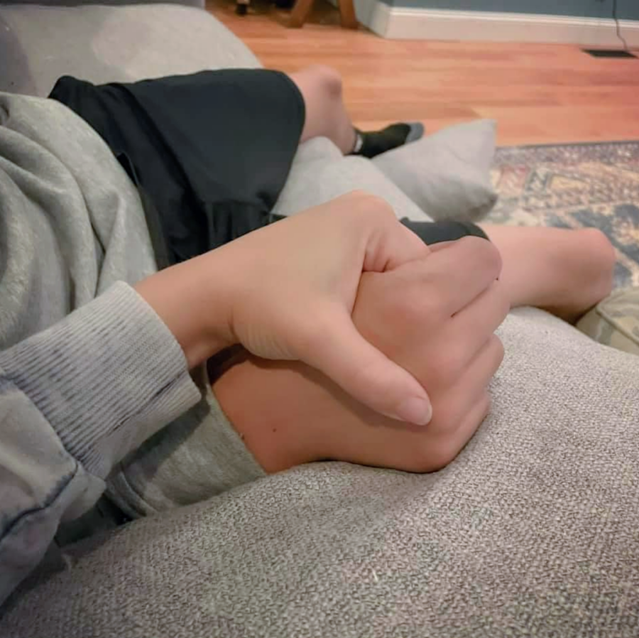 mother and son holding hands while sitting on a couch
