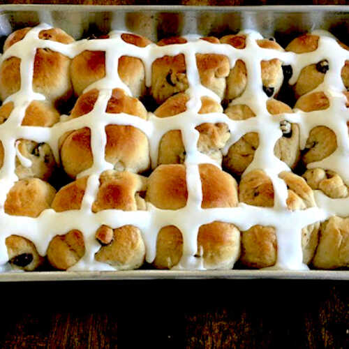 pan full of baked and iced hot cross buns