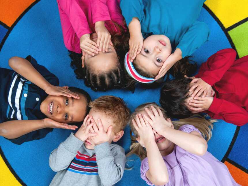 diverse preschoolers lying on colorful rug