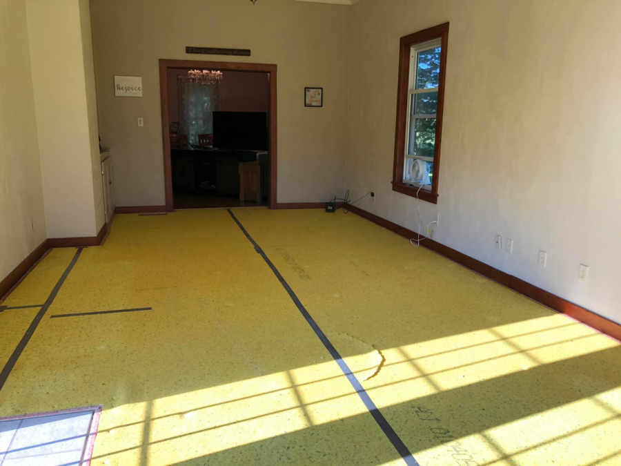 empty room with blue tape on floor to outline carpet