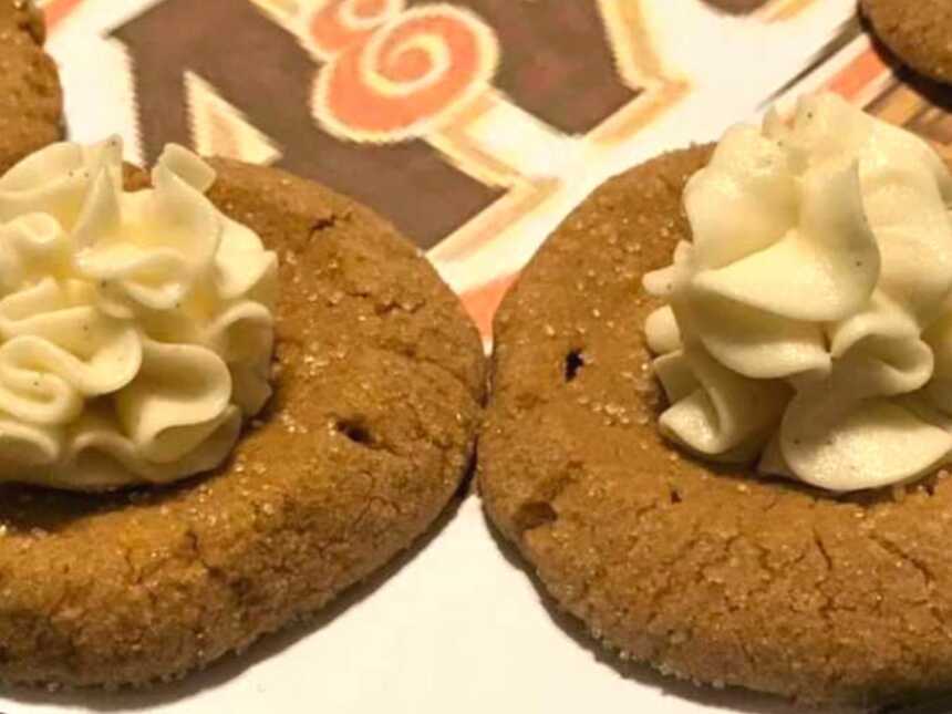 Two sugar-coated root beer float cookies topped with buttercream