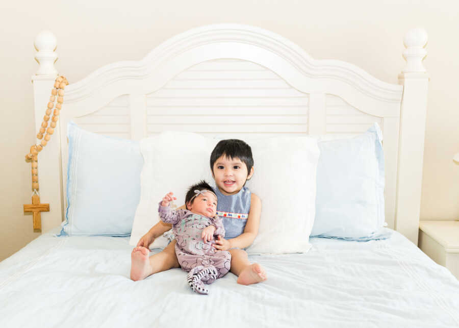 siblings in foster care sitting on bed together