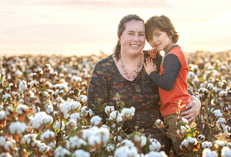 single mother with her adopted son in flower field