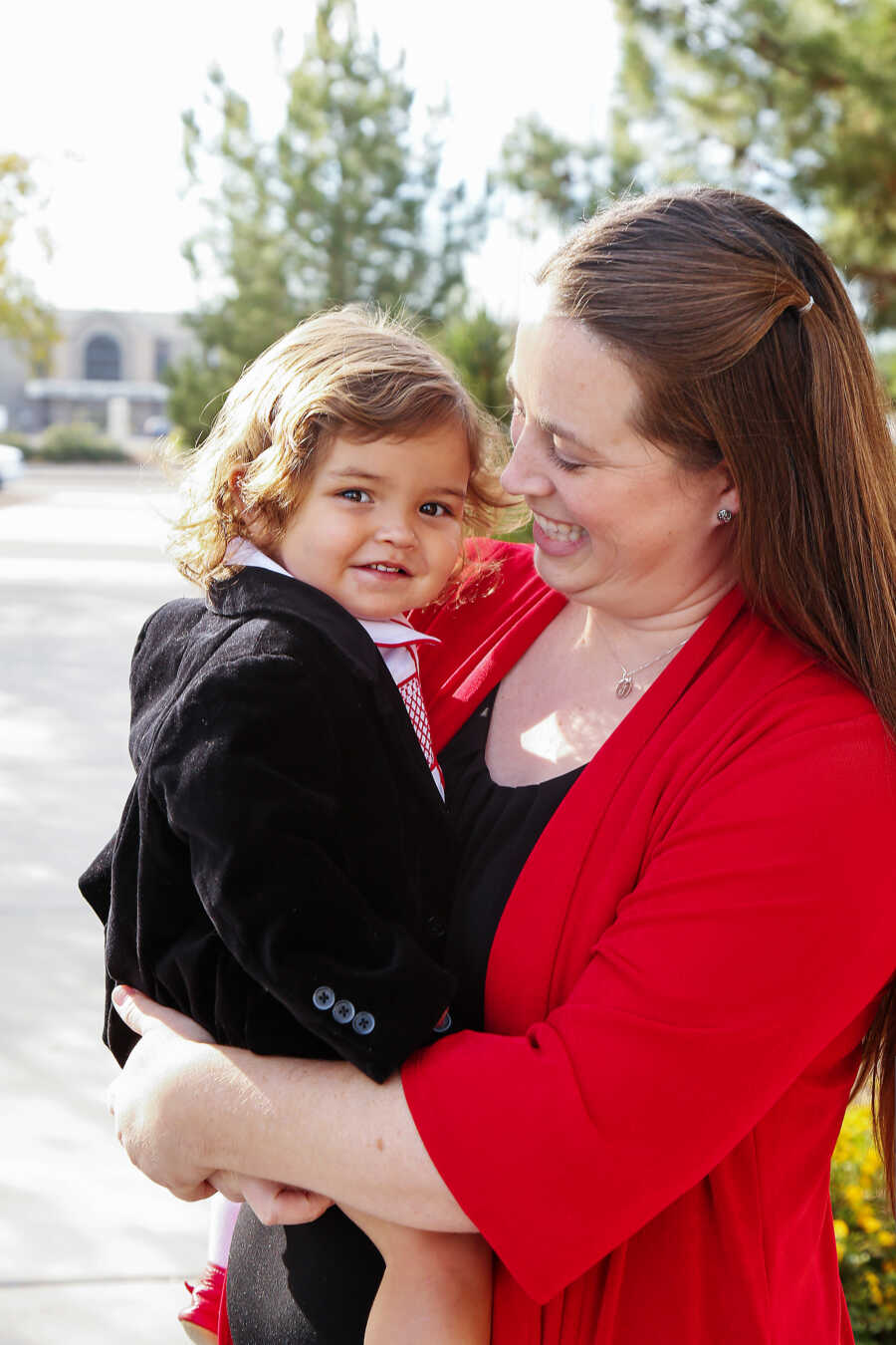 single mother holding her son on his adoption day