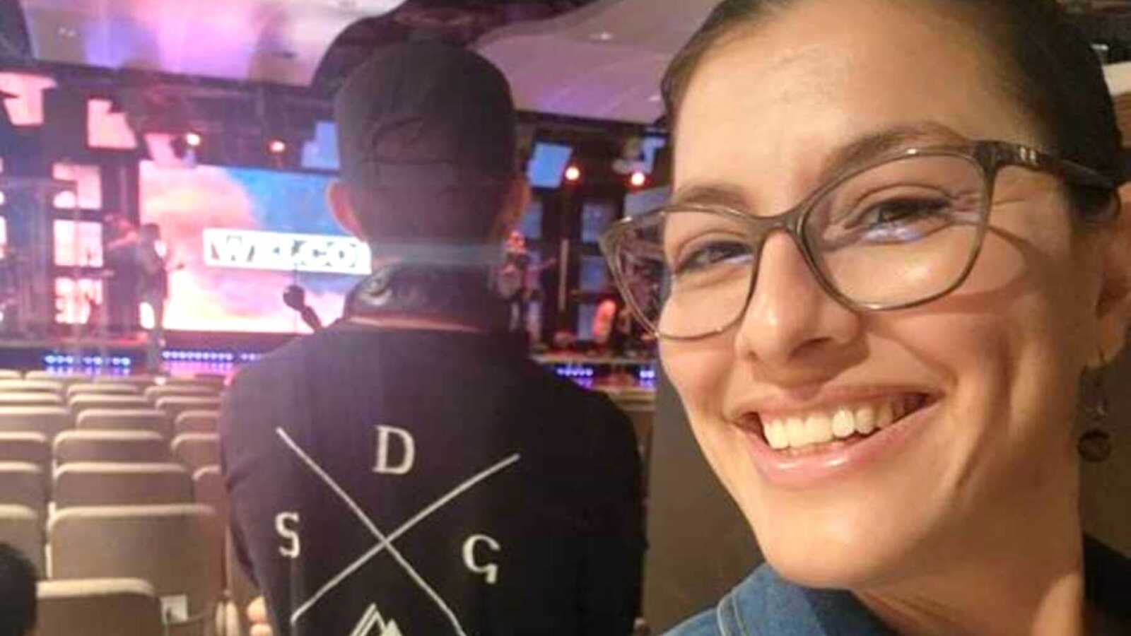 Mom smiling in selfie with teen son's back