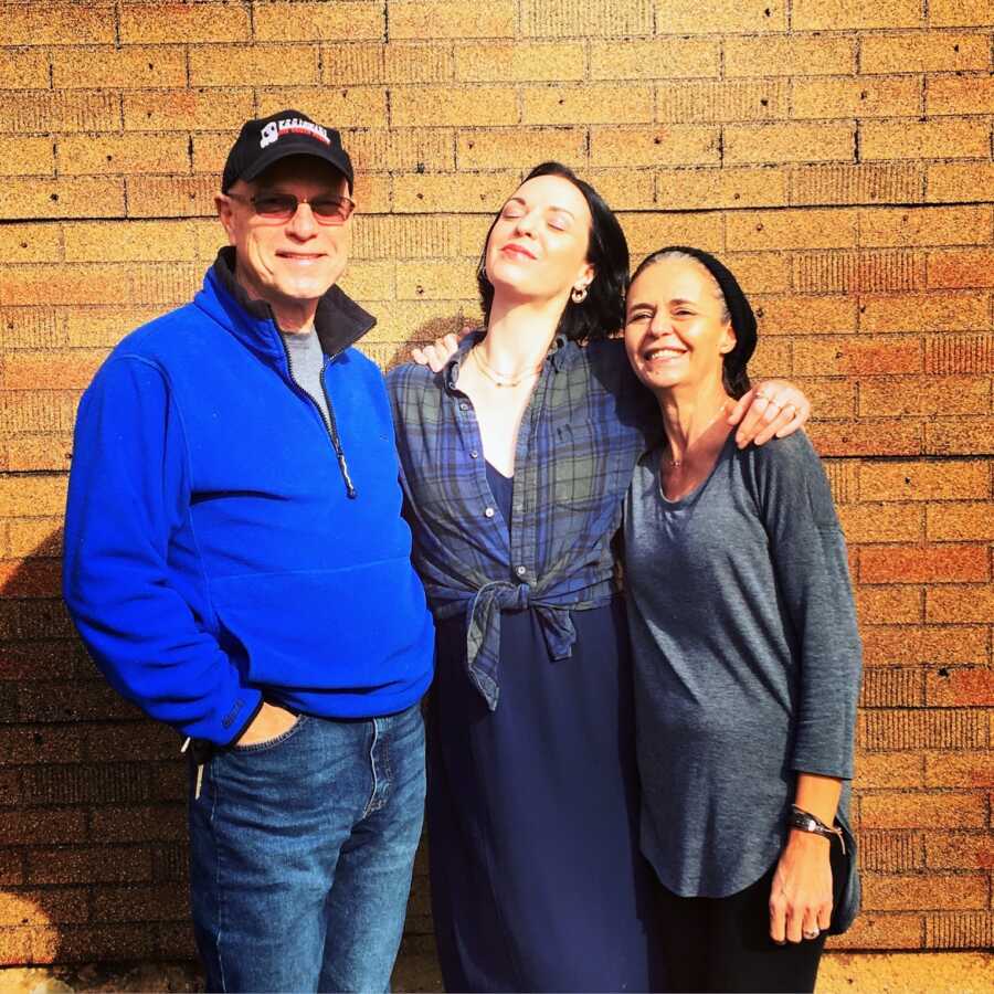 sober daughter with mother and father smiling