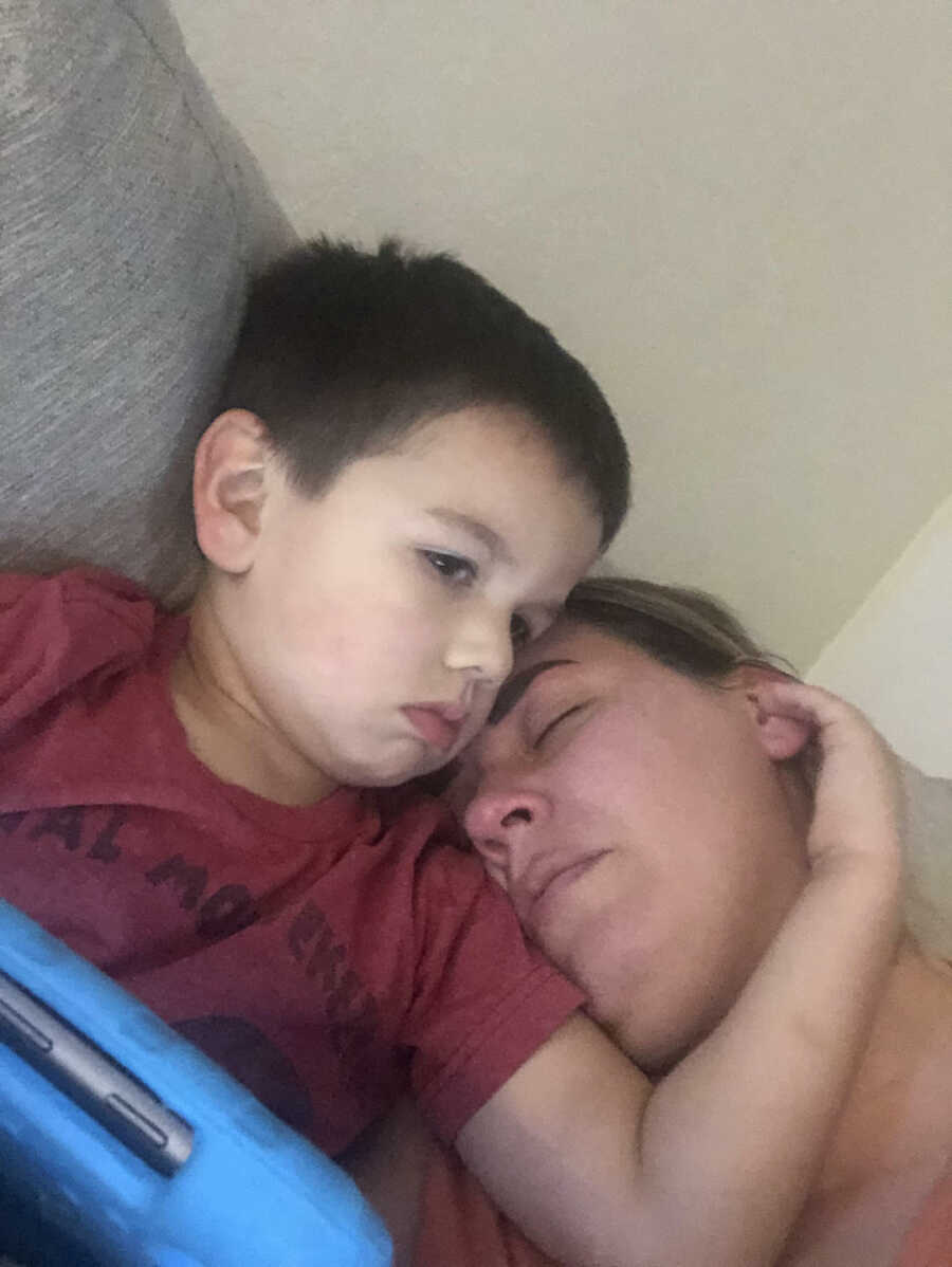 woman with chronic illness rests on her son while he holds her head