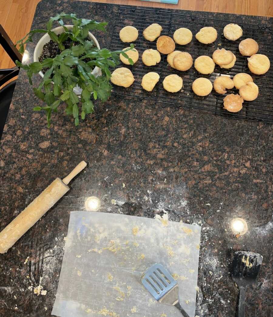 sugar cookies on cookie tray next to parchment paper and rolling pin