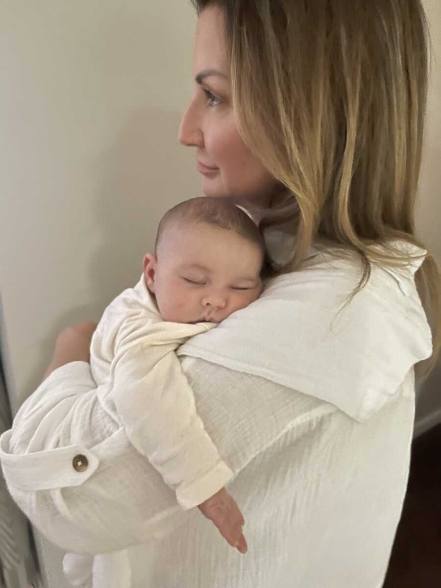 Woman holding baby daughter post open heart surgery