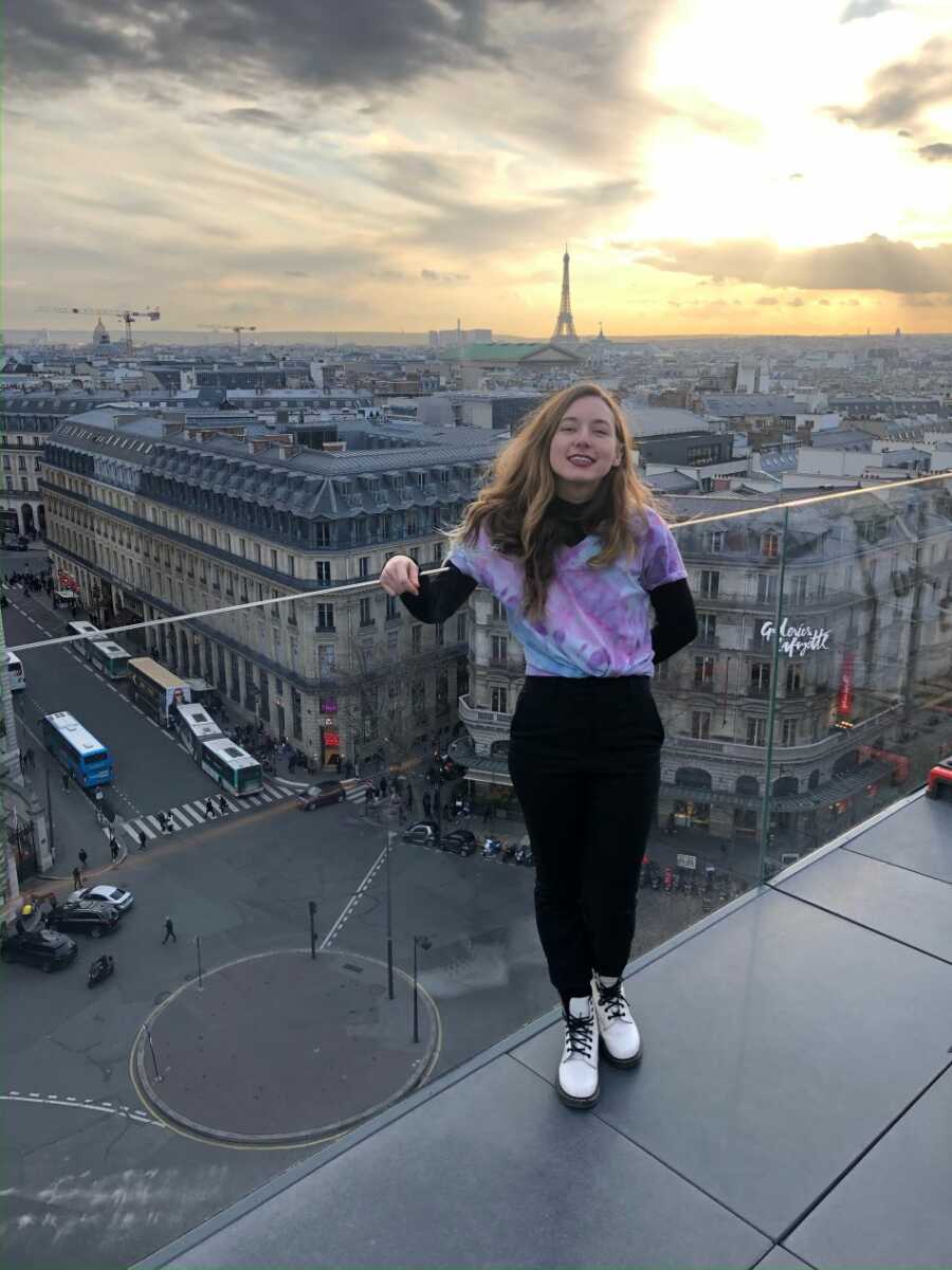 domestic abuse survivor leaning on railing in paris 