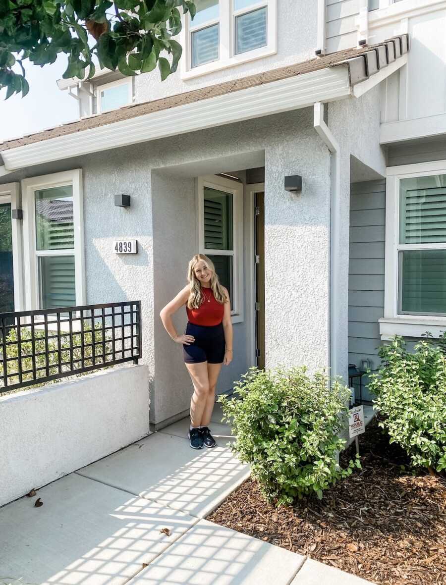 woman in front of her new apartment