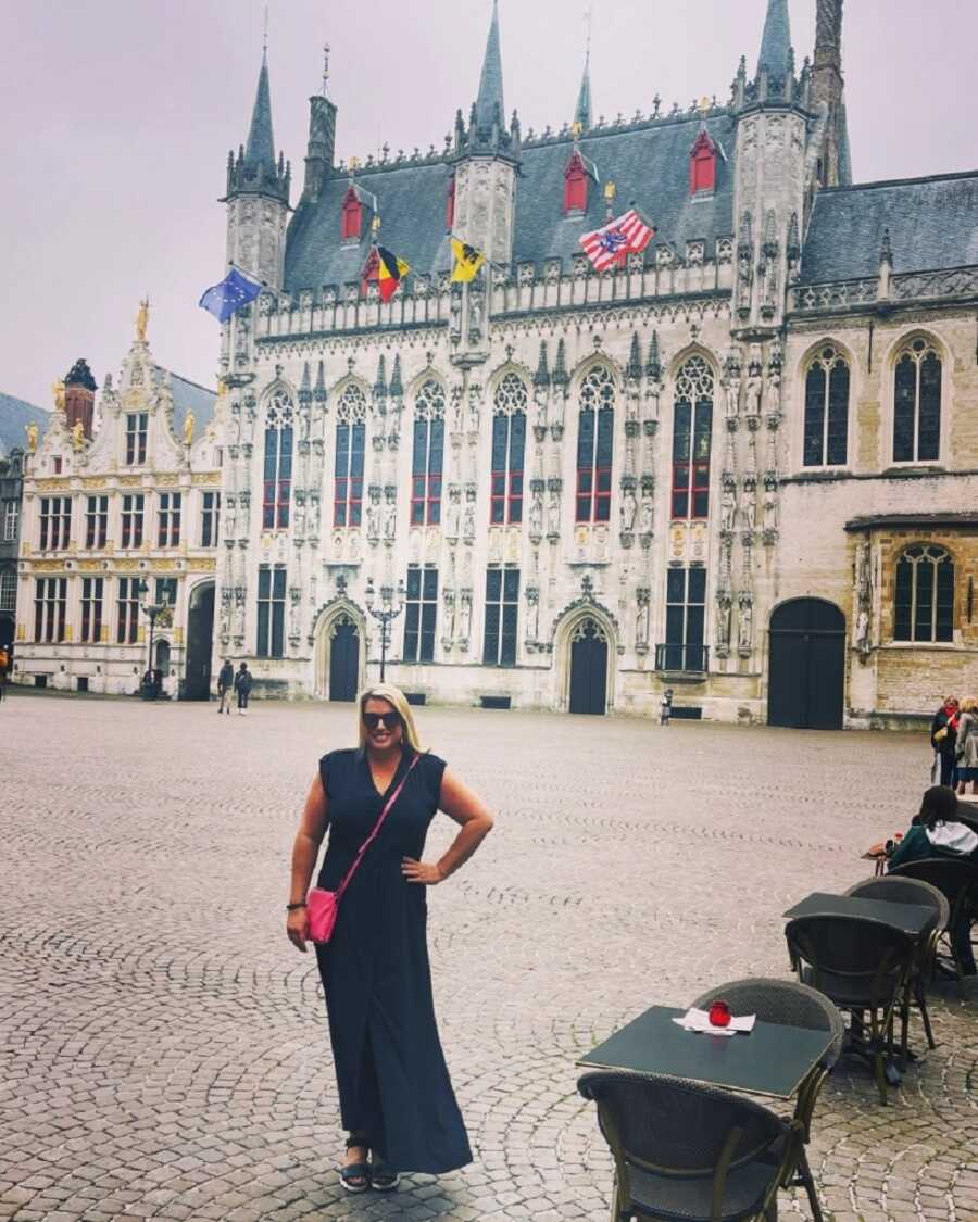 young widow traveling takes picture in front of historical landmark