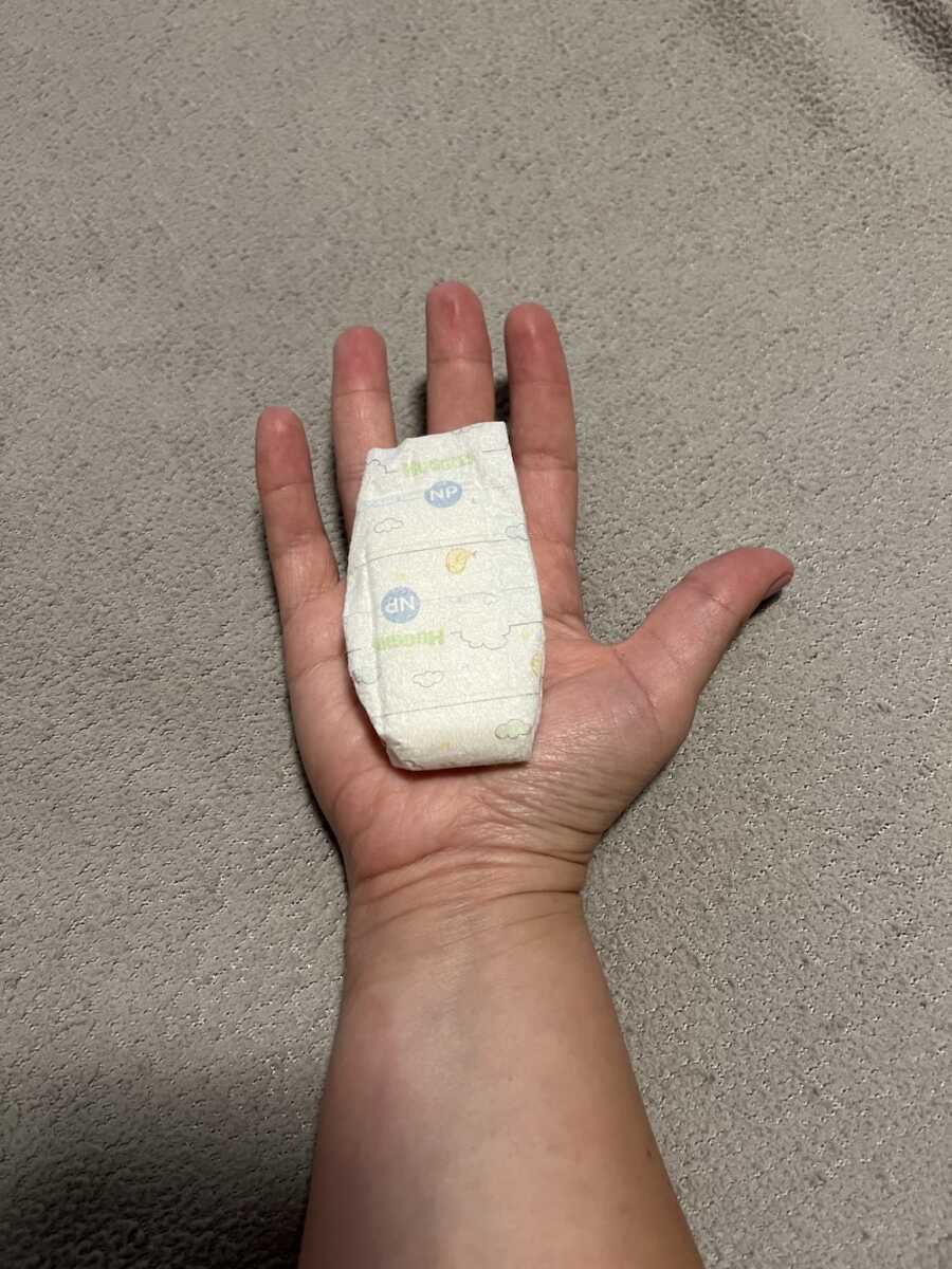 mom with NPremie sized diaper in her palm