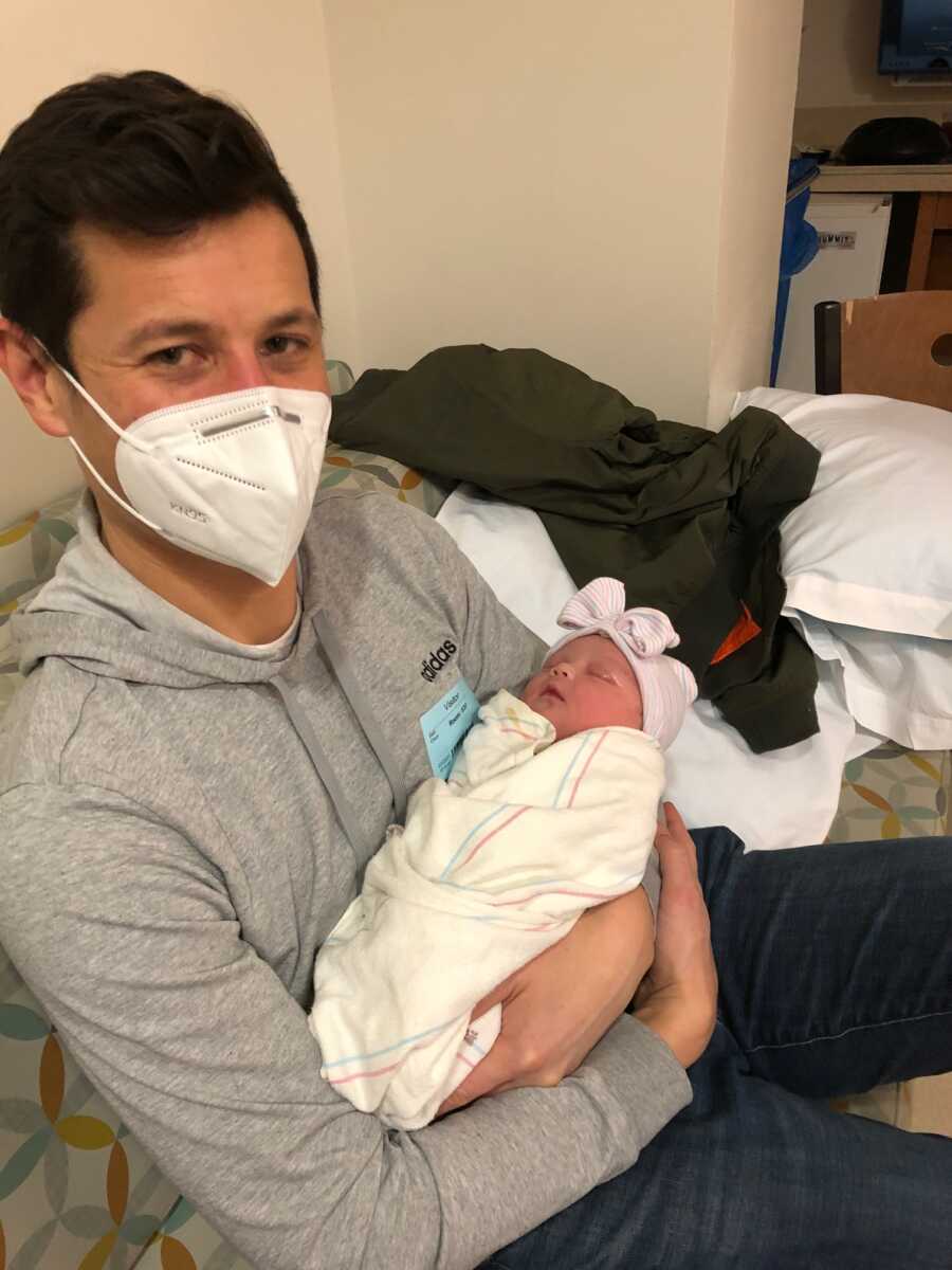 adoptive dad holding his newborn daughter 