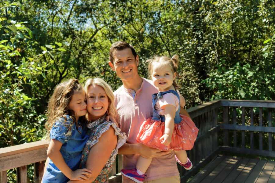 adoptive parents holding daughters in park