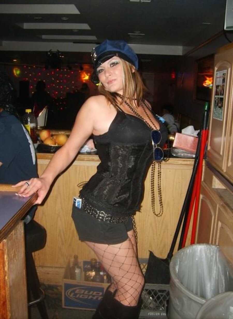 alcoholic woman wearing a cop costume partying