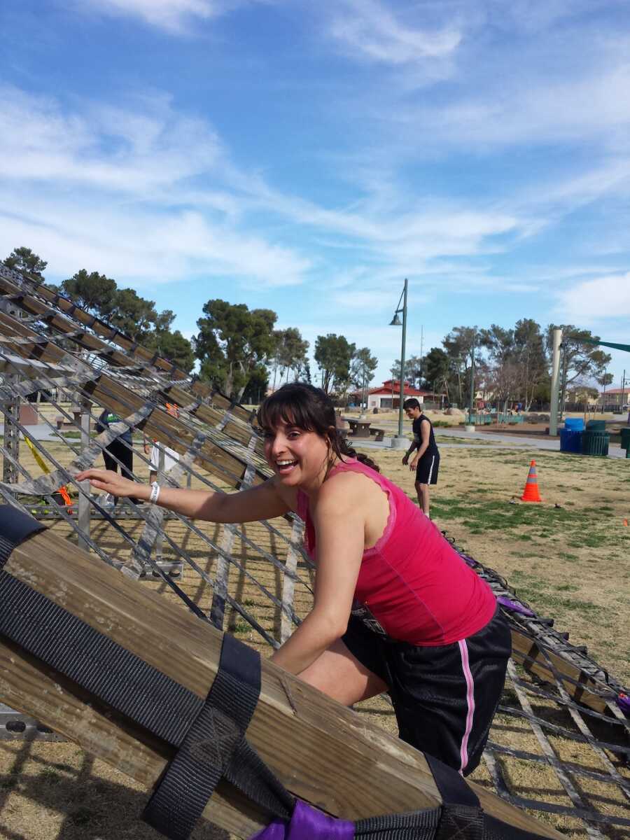 asthma warrior climbing up obstacle smiling