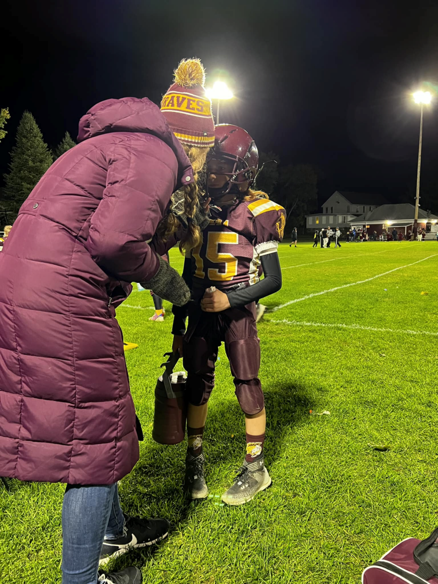 mom giving 11-year-old child who experiences anxiety pep talk during his football game