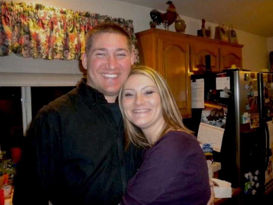 couple standing in kitchen together smiling