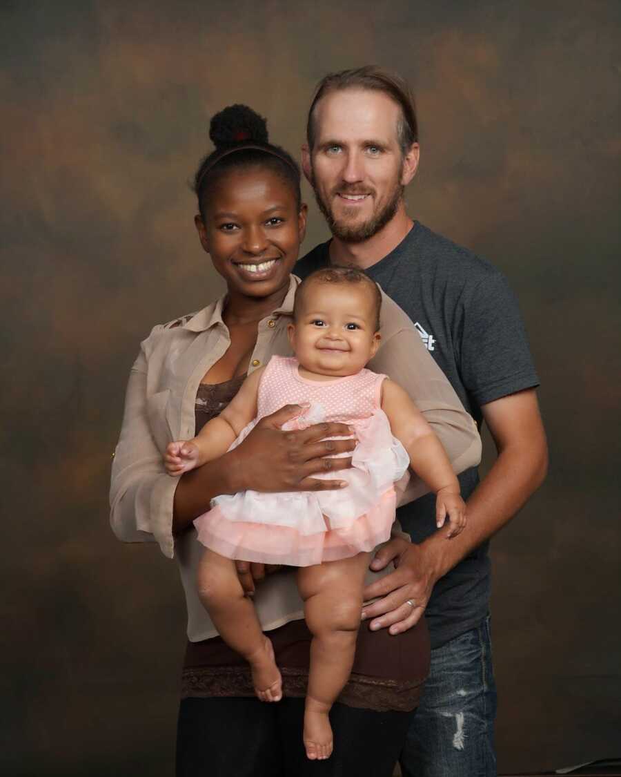 family portrait of wife husband and baby on a brown background
