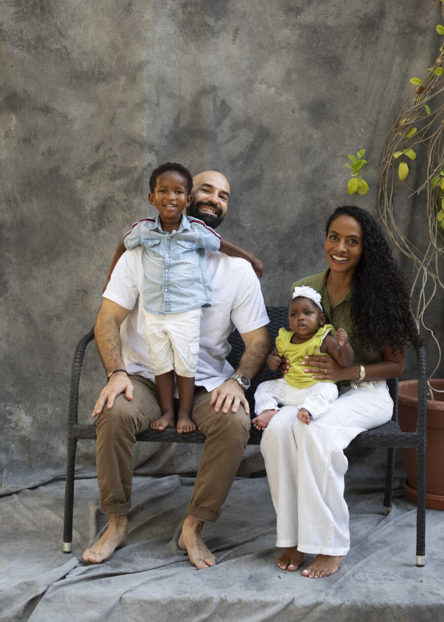 family sitting on bench together for a Vogue photoshoot