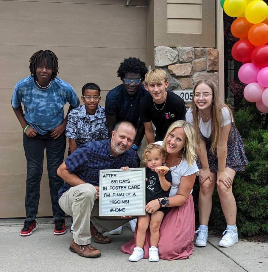 family standing together on the adoption day of their youngest daughter