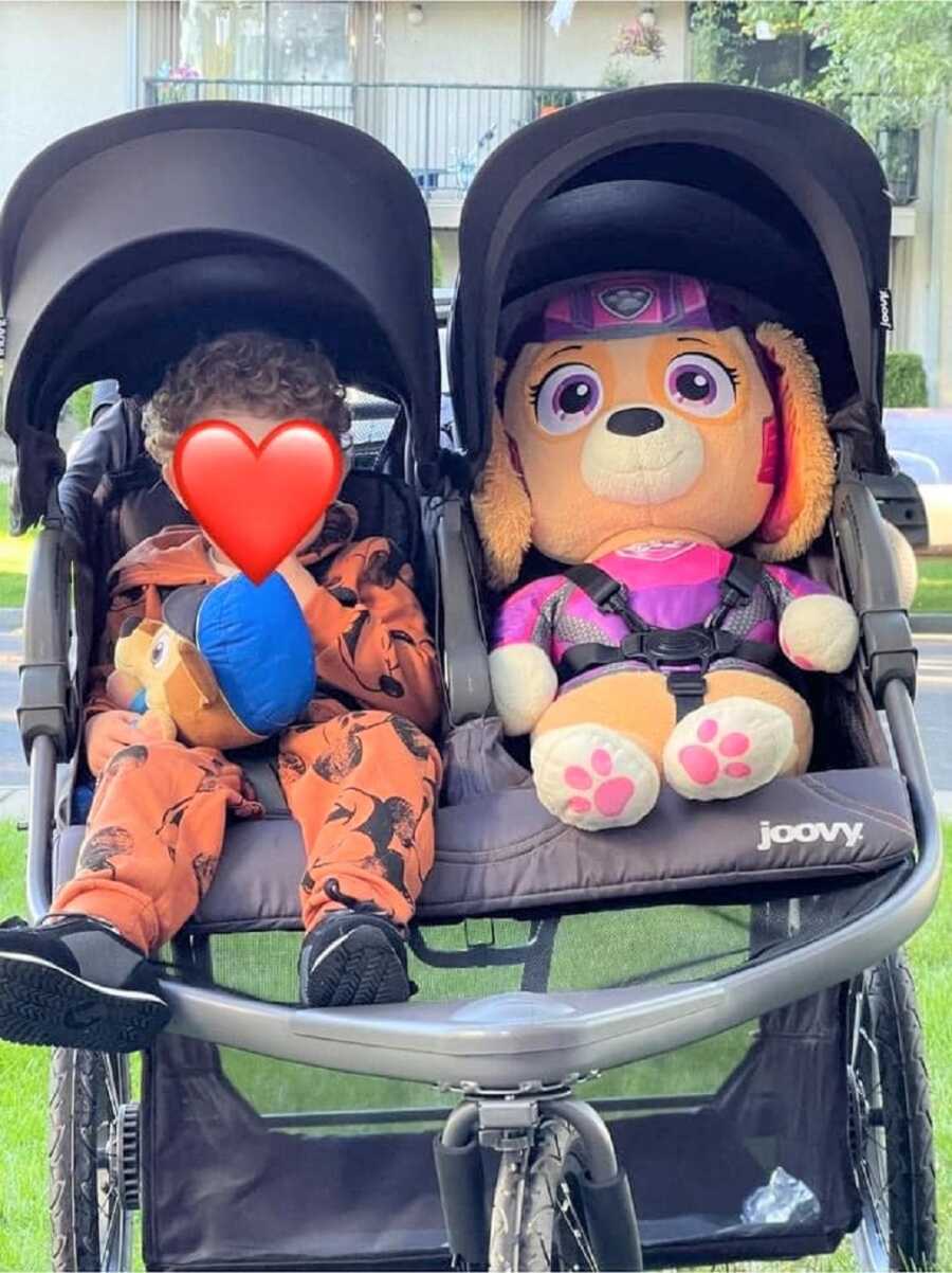 foster boy in stroller next to stuffed animal