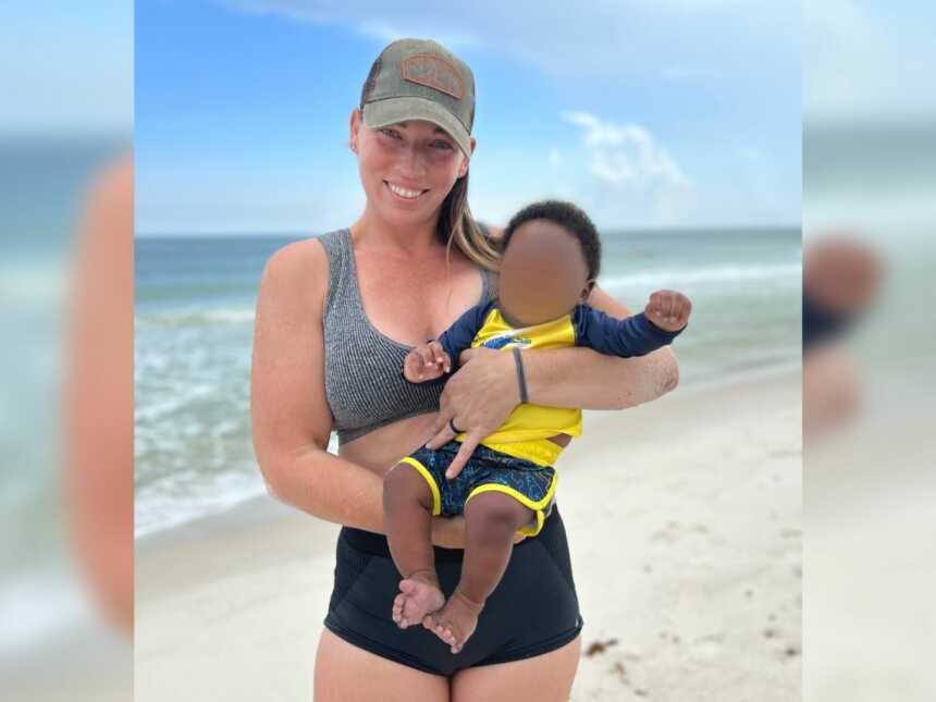 foster mom holds baby boy at the beach