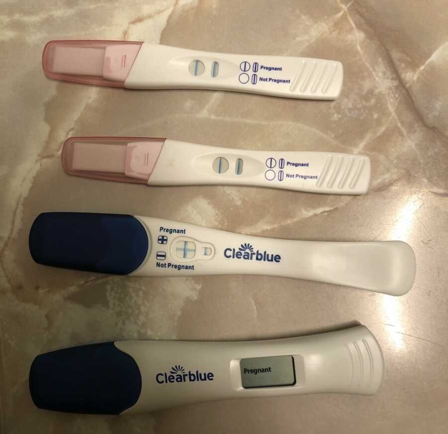 four positive pregnancy tests laid out on counter