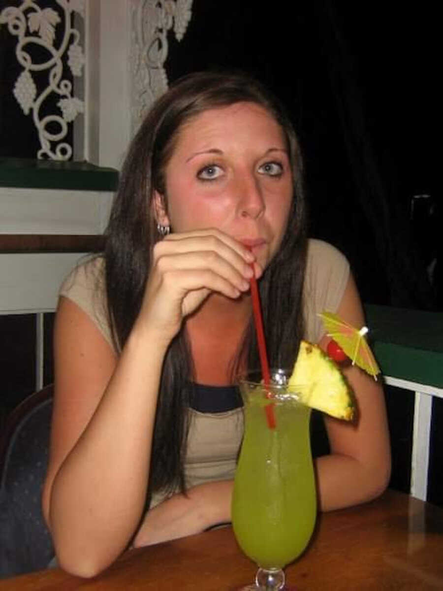 woman struggling with addiction drinking a fruity cocktail