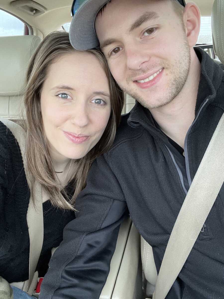 husband and wife take a selfie together while in the car
