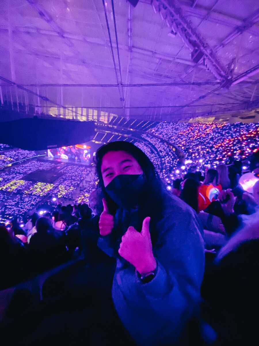 Korean adoptee giving thumbs up while at KPop concert