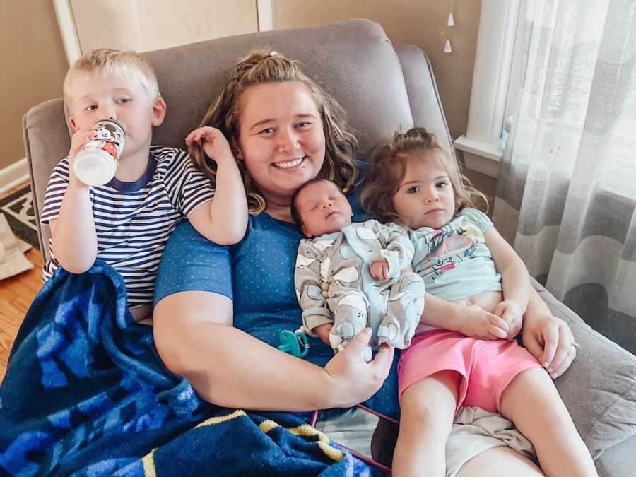 mom sits with three children on chair