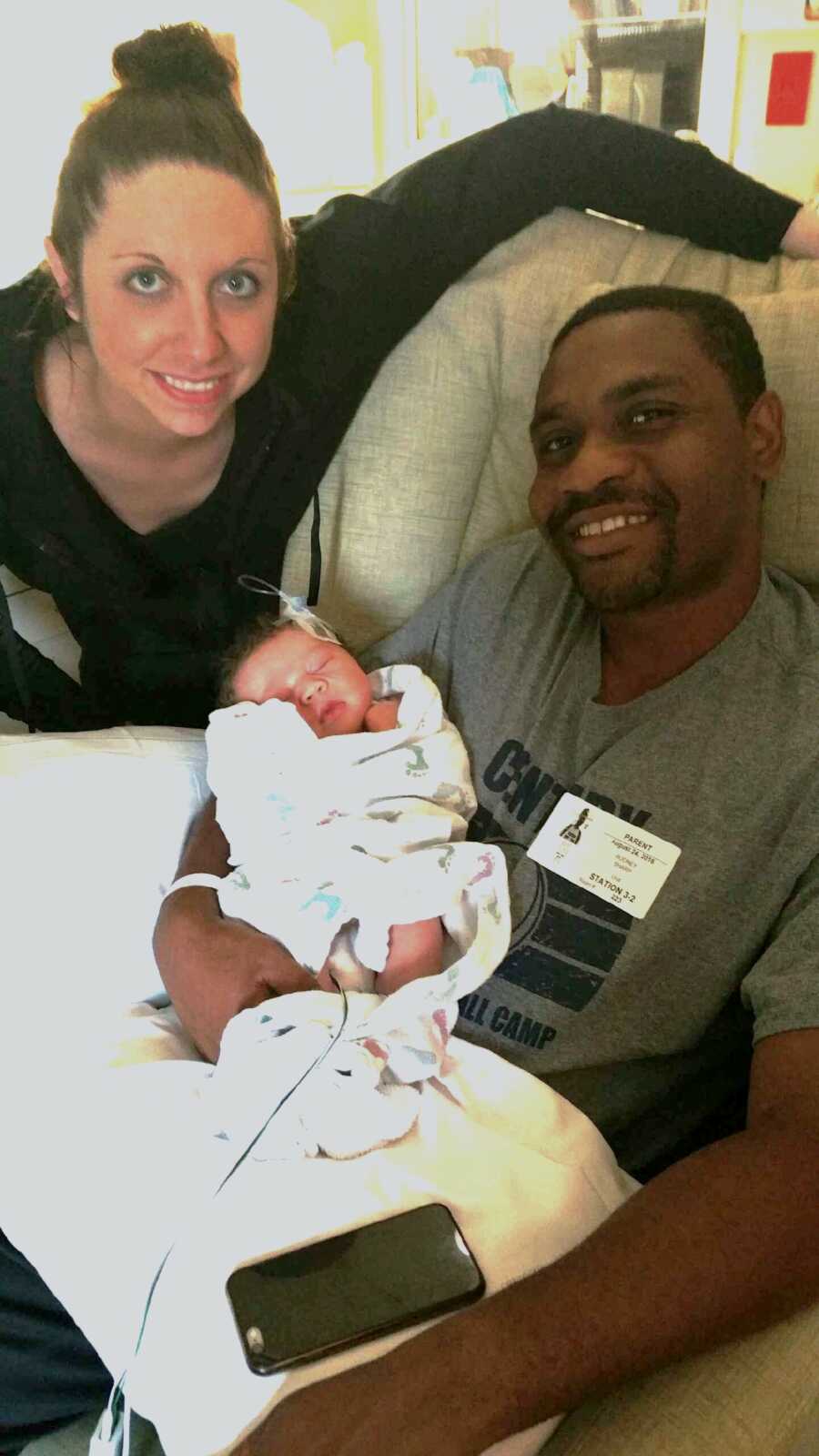 new parents hold their baby son in the hospital