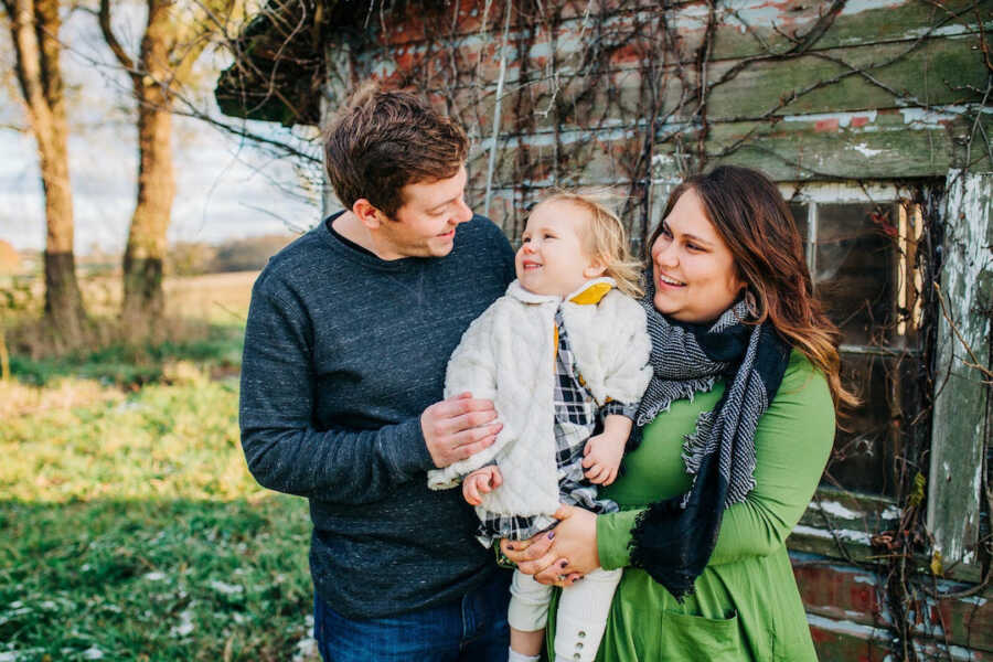 parents holding and looking at their daughter