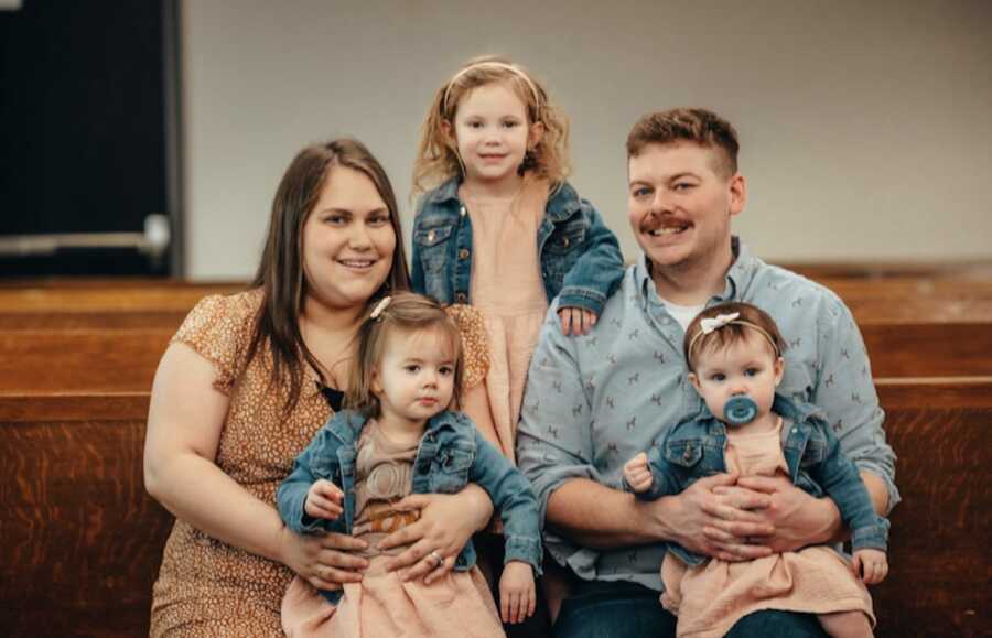 parents with two biological daughters and adopted daughter on adoption day