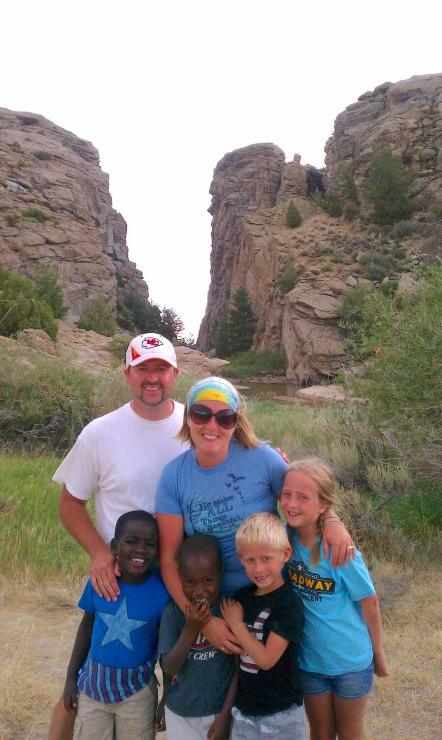 parents standing with two adoptive sons and two biological children