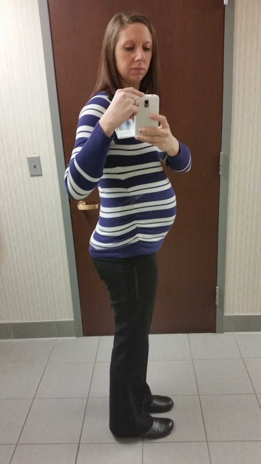 woman pregnant with son taking a mirror selfie