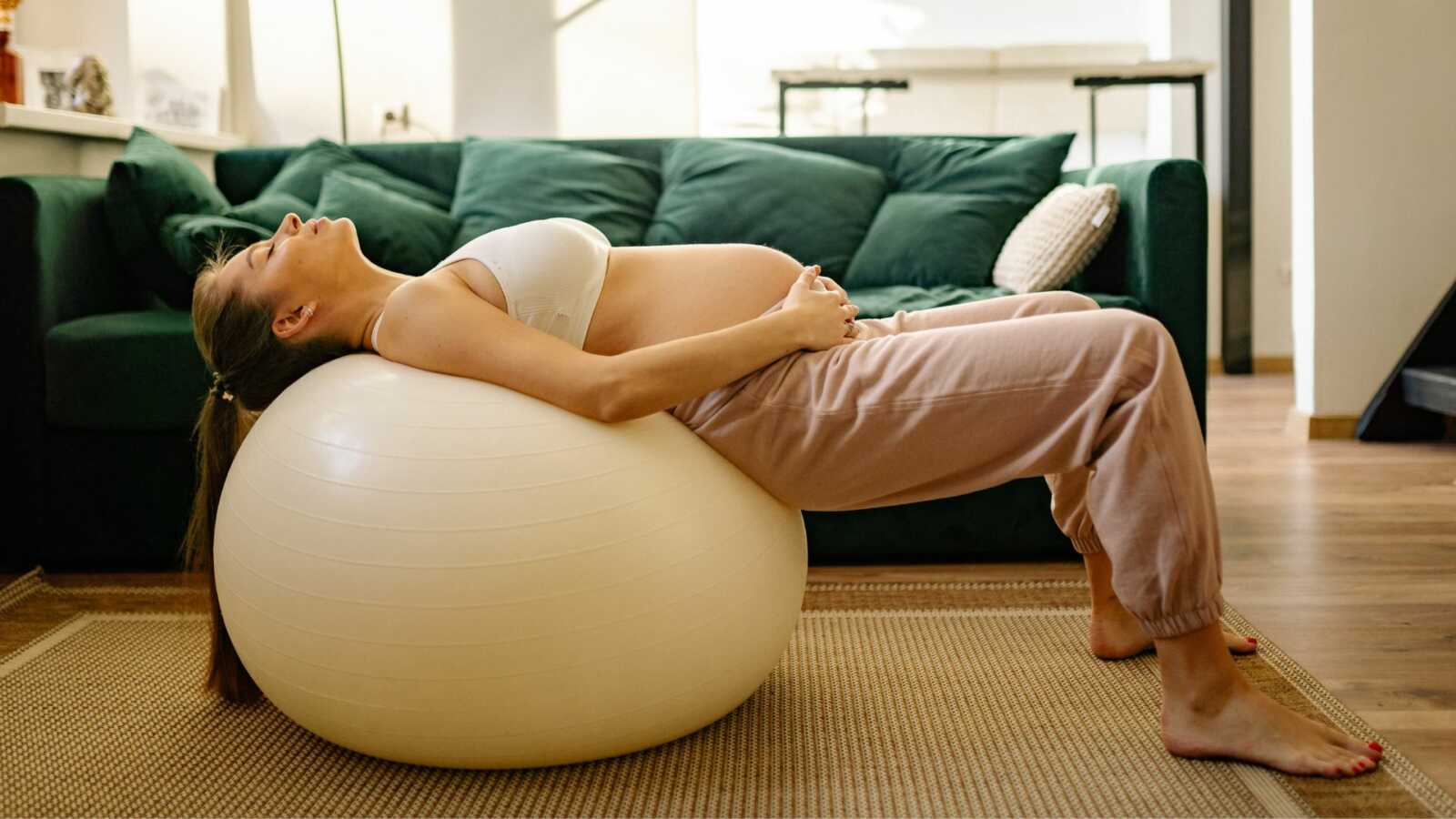 pregnant woman laying on yoga ball
