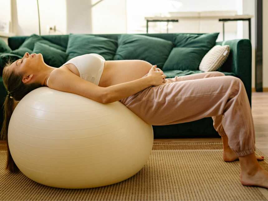 pregnant woman laying on yoga ball